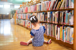 under the couch book series girl on floor in library