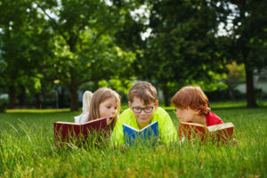 under the couch book series kids reading on grass